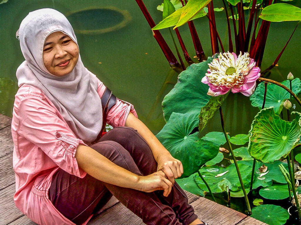 A woman beside a lotus flower, Southeast Asia